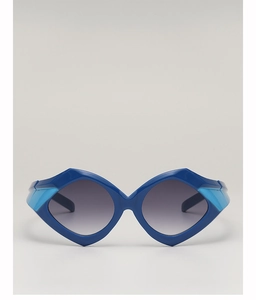 Close-up of oversized geometric sunglasses featuring thick deep blue frames and grey lenses