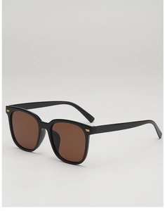 Detailed close-up of black square sunglasses with gold accents on the temples