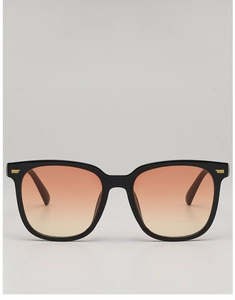 Detail of square black sunglasses with orange gradient lenses and gold metal studs