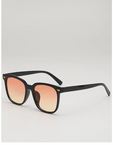 Detail of square black sunglasses with orange gradient lenses and gold metallic accents