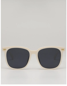 Detailed front view of cream-colored square sunglasses with gold accents and dark lenses