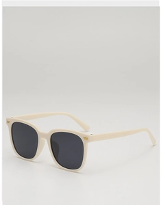 Close-up of creamy white square sunglasses with gold metal accents and dark grey lenses