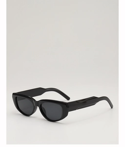 Detail view of glossy black wide-temple cat-eye sunglasses with dark lenses