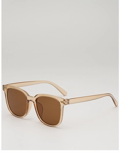 Detail view of large square transparent champagne sunglasses with dark brown lenses