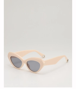 Detail of cream cat-eye sunglasses featuring metal ring accents on the temple tips