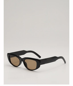 Detail view of cat eye sunglasses with glossy black frames and amber lenses