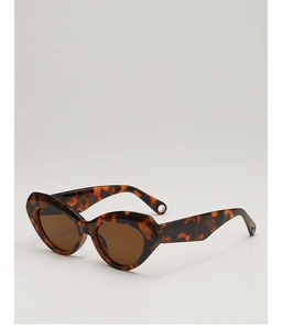 Detail of tortoiseshell cat-eye sunglasses featuring silver hollow rings on wide temples