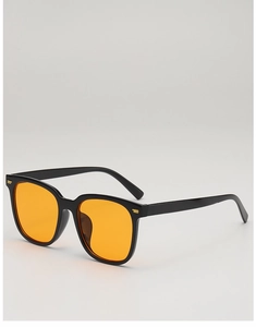 Detail view of square black frames with orange lenses and golden metal stud accents