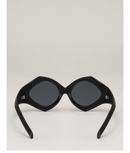 Detail view of bold black geometric sunglasses showing hinge and wide temple arms construction