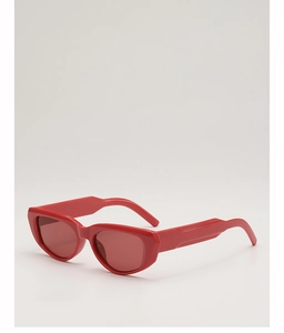 Detail view of bold red cat-eye sunglasses with thick frames and matching red lenses
