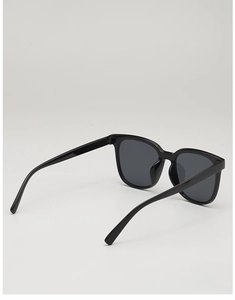 Detail view of glossy black square sunglasses frame with sleek integrated nose bridge