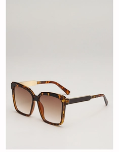 Detail view of tortoiseshell square sunglasses with gold metal temples and brown lenses