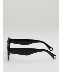 Side view of trendy black cat-eye sunglasses with wide temples and hollow metal detail