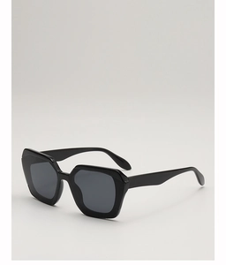 Detail of thick black geometric frame and dark lenses of retro polygon sunglasses