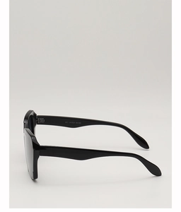 Side view of black oversized square sunglasses with thick glossy frames and dark lenses