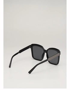 Detail view of square sunglasses featuring black resin frames and silver metal temple accents