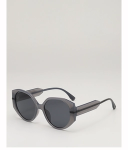 Detail of dark grey geometric sunglasses with thick translucent frames and wide temples