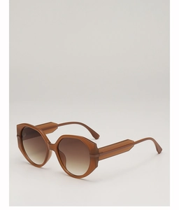 Detail view of oversized round sunglasses with geometric edges and gradient brown lenses