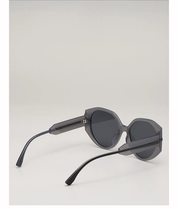 Detail view of round vintage oversized sunglasses with gray transparent frames and dark lenses