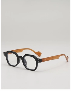 Detail of black octagonal polygon sunglasses with transparent amber temple and silver rivets