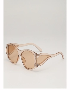 Detail of oversized punk sunglasses with transparent skin-tone frame and teardrop side cutouts
