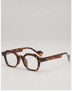 Detail view of tortoiseshell polygon sunglasses with wavy temples and metal hinges