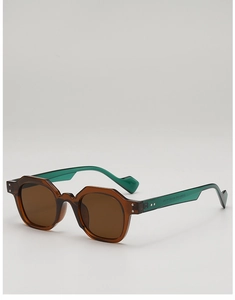 Detail of polygonal sunglasses featuring translucent brown frames and green temples with rivets