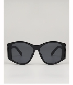 Close-up of oversized black punk sunglasses with thick frames and cat-eye angles