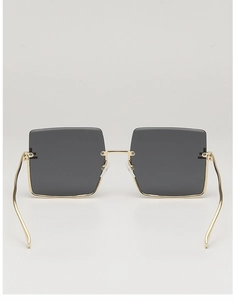 Detail view of large square metal sunglasses with gold frames and dark grey lenses