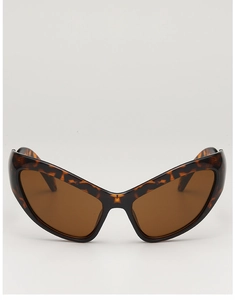 Macro view of oversized cat-eye sunglasses with tortoiseshell frames and amber lenses