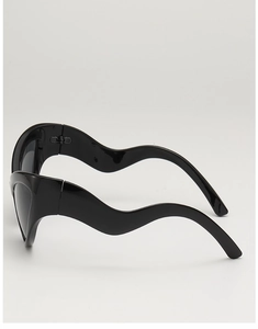Detail shot of black sunglasses featuring unique wavy temple arms and glossy finish