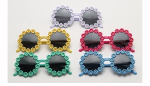 Detail view of colorful daisy flower sunglasses for kids in five different pastel shades