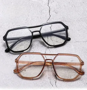 Close-up of stylish double-bridge polygon oversized glasses in black and transparent tea colors