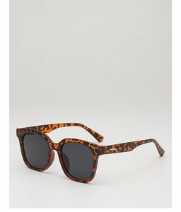 Detail einer quadratischen übergroßen Sonnenbrille mit dunklen Gläsern und Schildpatt