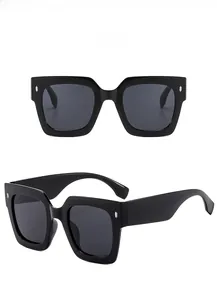Detail of black square frame sunglasses with silver rivets and gray lenses