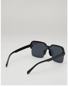 Detail view of thick matte black frame and dark grey lenses on square oversized sunglasses