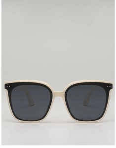 Macro detail of creamy white square sunglasses with metal rivets and black lens trim