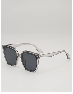 Detail of square frame sunglasses featuring transparent grey finish and silver rivets