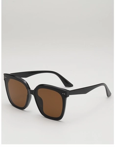 Close-up of square black sunglasses with brown lenses and silver stud details