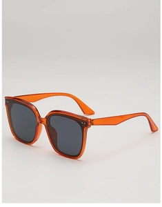 Detailed 45-degree angle of translucent orange square frame sunglasses with silver dots