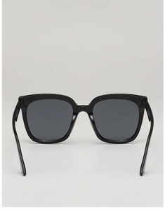 Front view of stylish black square frame sunglasses with dark lenses on a grey background