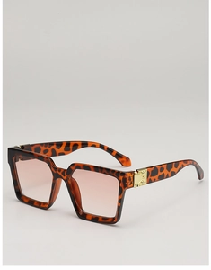 Close-up of tortoise shell square frame sunglasses with golden embossed metal hinge detail