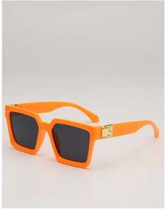 Close-up of orange square sunglasses with dark grey lenses and gold metal rivets