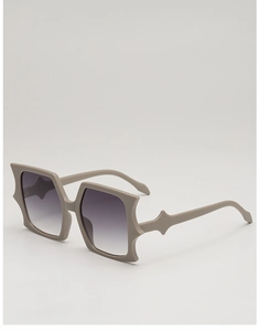 Detail view of avant-garde geometric butterfly sunglasses with matte khaki frames and gradient lenses