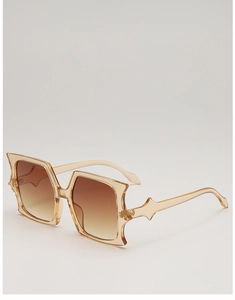 Detail of oversized amber butterfly sunglasses with unique geometric frame edges