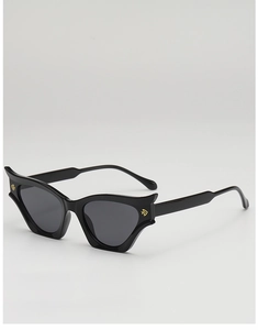 Detail of black cat-eye sunglasses featuring bold frame wings and golden V accents