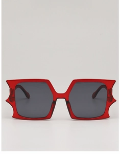 Close-up of avant-garde red oversized sunglasses with unique spiked geometric frame edges