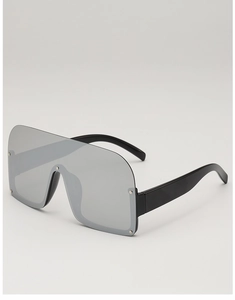 Macro side view of silver mirrored sunglasses featuring decorative metal rivets on the lens