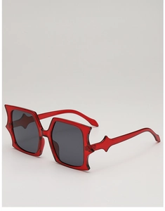 Detail of red translucent butterfly sunglasses featuring avant-garde star-shaped frames