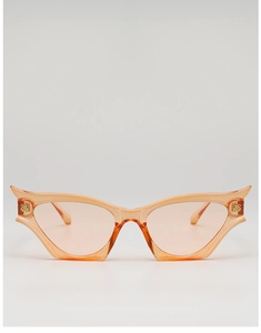 Detail of trendy cat-eye sunglasses with orange translucent frames and gold metal hinges